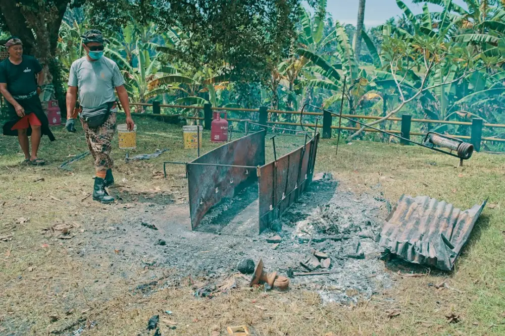 Men preparing a barbecue pit with firewood and cooking equipment, illustrating learning barbecue processes through practice